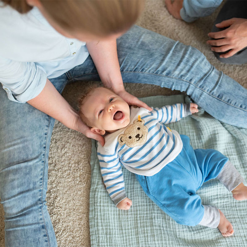 Baby auf dem Schoß eine Osteopathin